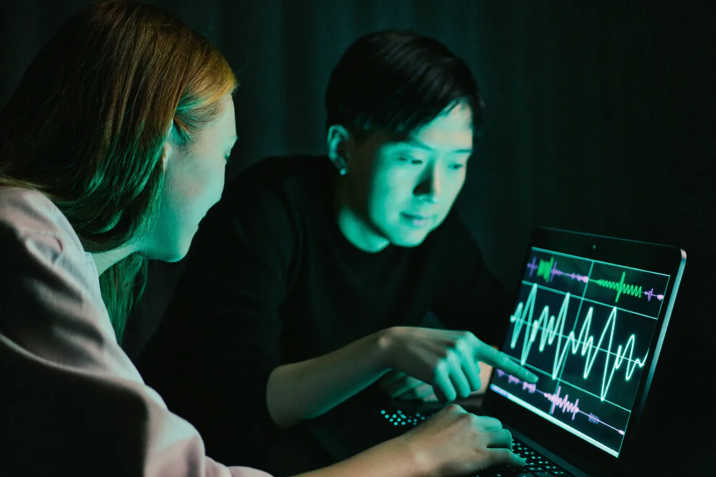 Two students reading live brainwave signals on a laptop